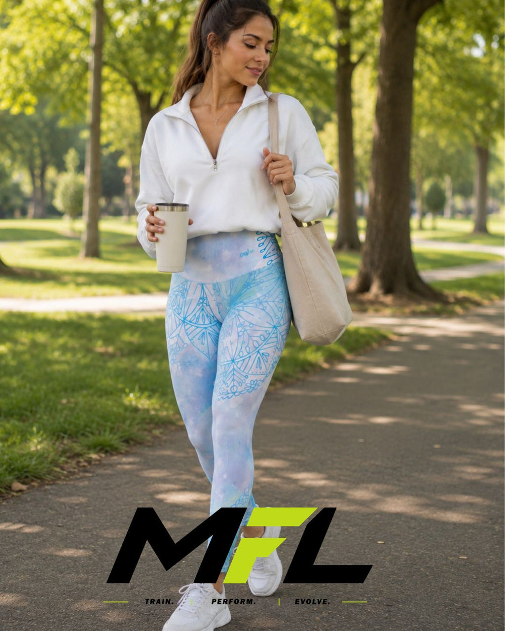 A woman walking on a tree-lined path wearing light blue and white patterned Arctic Serenity leggings, a white quarter-zip top, white sneakers, and carrying a beige tote bag and a coffee cup. 