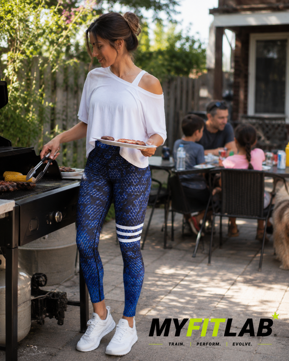 Woman wearing Blue Venom Leggings while having a bbq with her family 