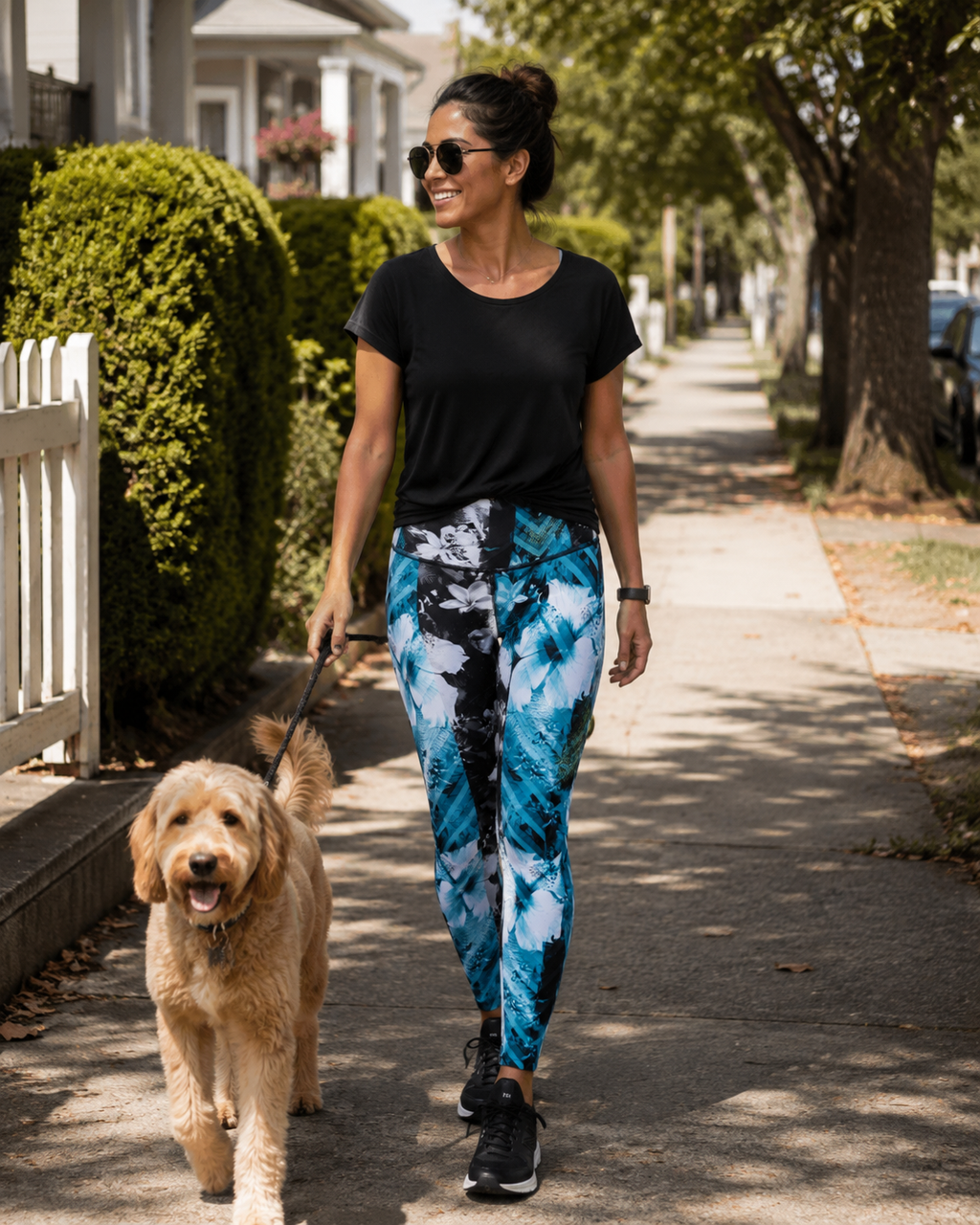 Woman wearing an Pcean Rush Leggings with blue, white and black design walking her dog